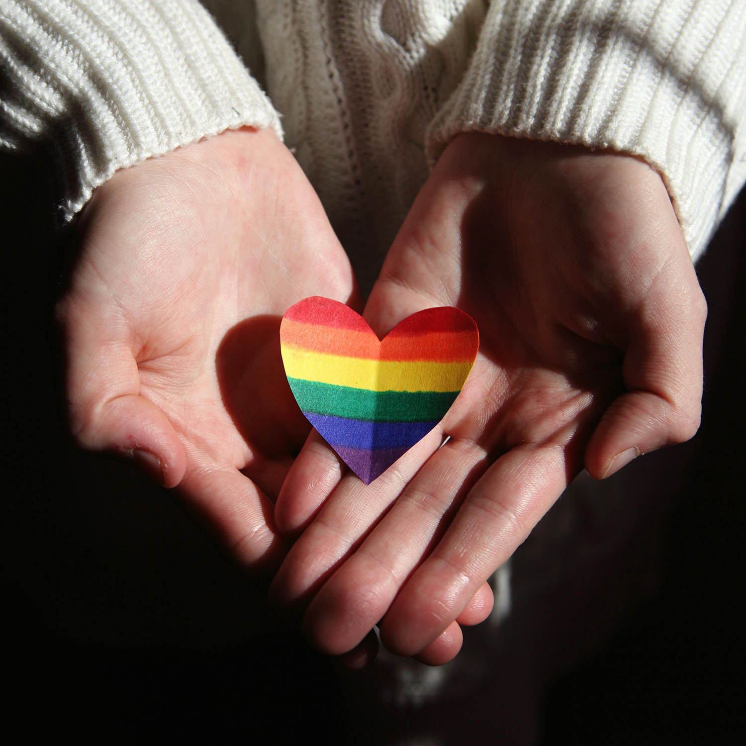 Rainbow heart held in hands