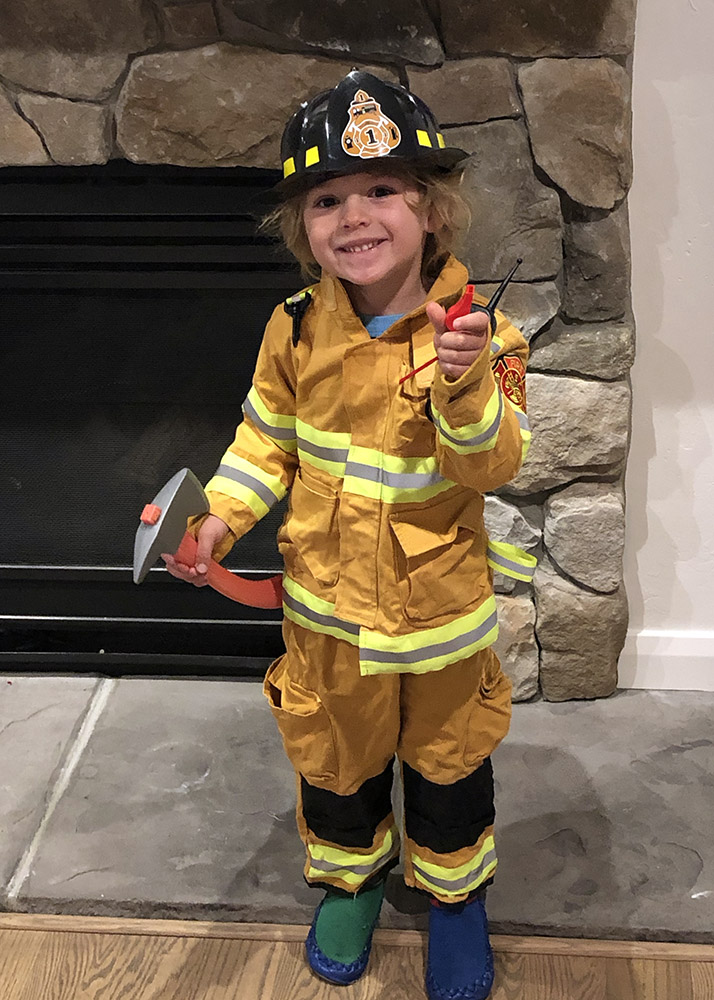 a little kid dressed as a fire fighter