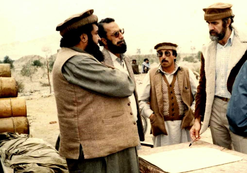 A historical photo of four men talking with each other.