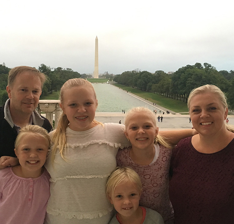 The Dunn family, smiling at the camera, with the Washington Monument in the background