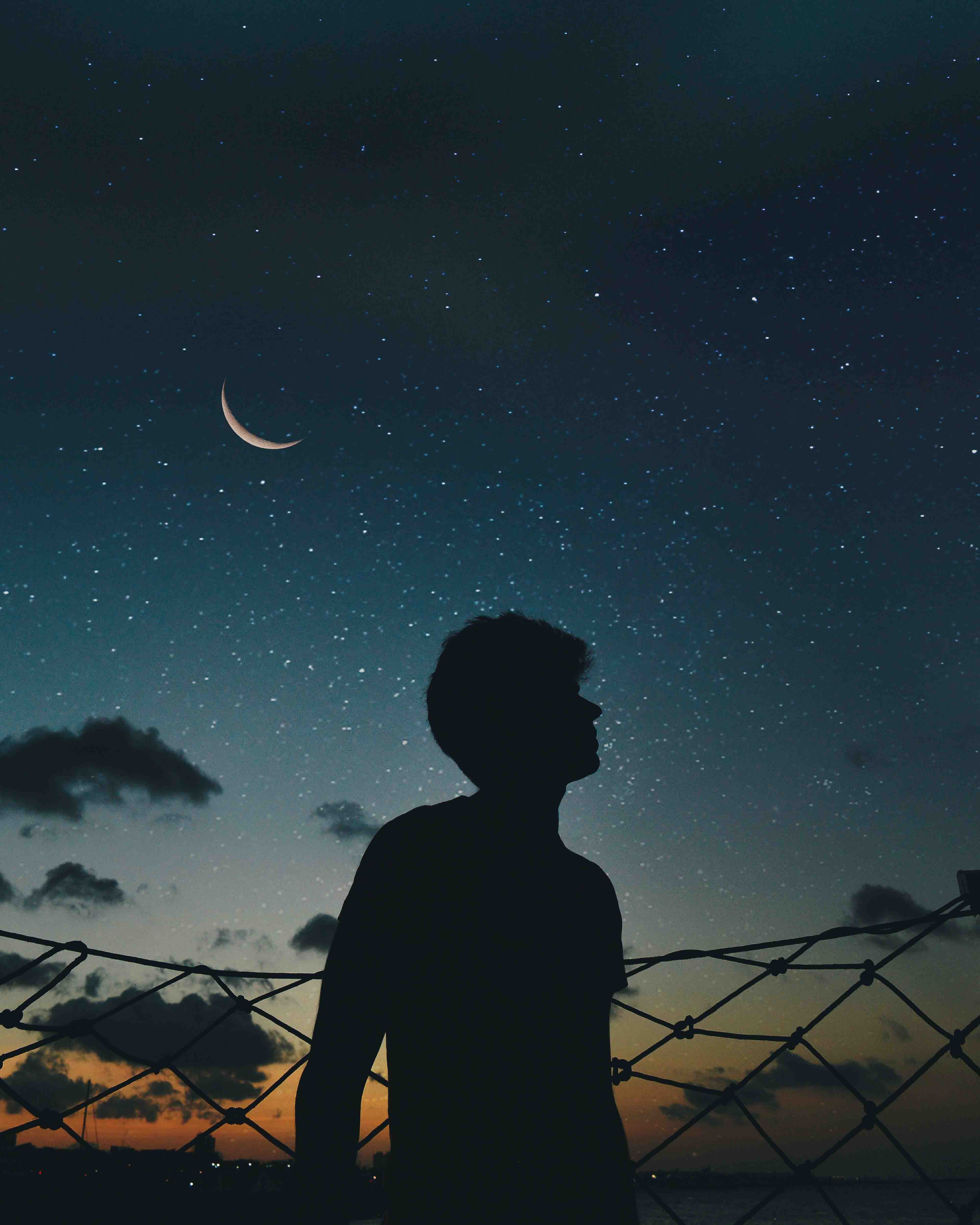 a man silhouetted against a night sky