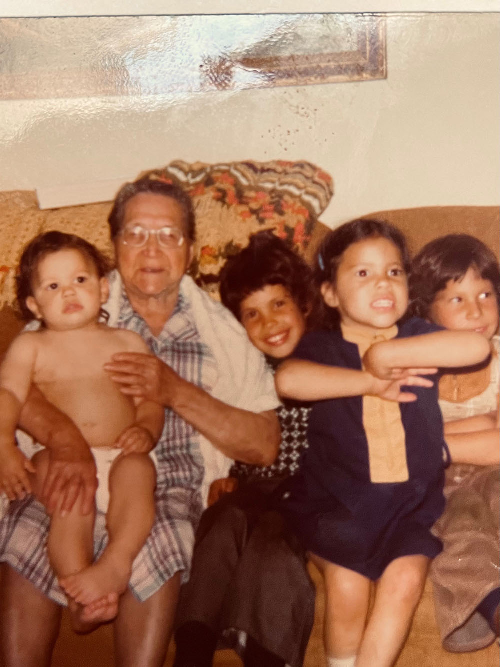 Photo of older woman with a little boy on her lap, next to three other children