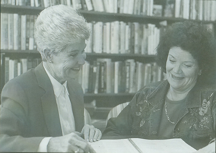 Photo of Dr. Lou Ann Jorgensen and Dr. Audeane Cowley looking at an open book