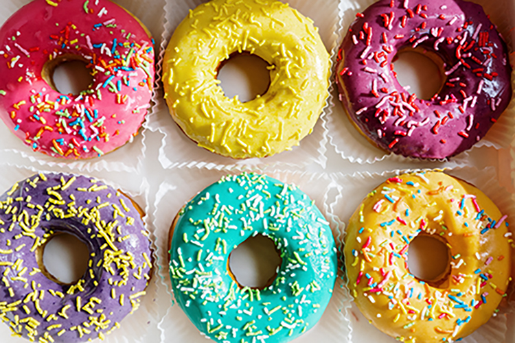 a close up shot of a colorful box of donuts