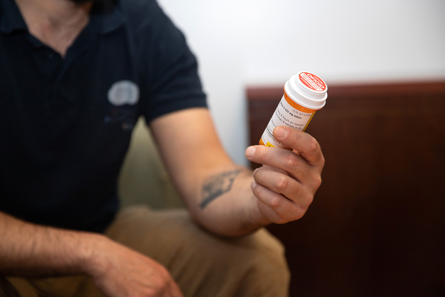 A man holds a bottle of prescription opioids